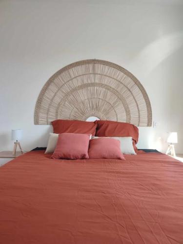 une chambre avec un grand lit avec des draps et des oreillers rouges dans l'établissement Maison charmante à proximité de Luçon, à Les Magnils-Reigniers