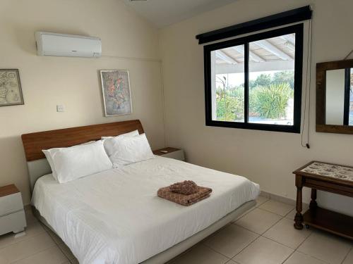a bedroom with a large white bed with a window at Villa Margarita Latchi in Lachi