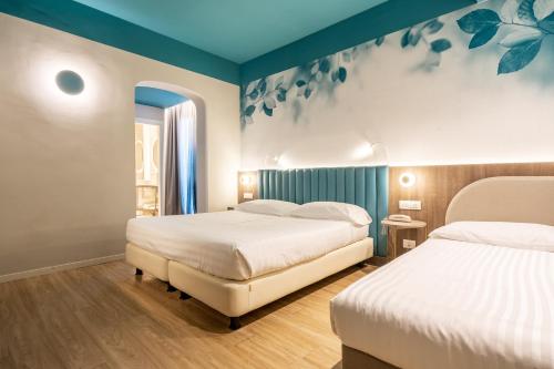 2 Betten in einem Zimmer mit blauen Wänden in der Unterkunft Hotel Regina Elena 57 & Oro Bianco SPA in Rimini