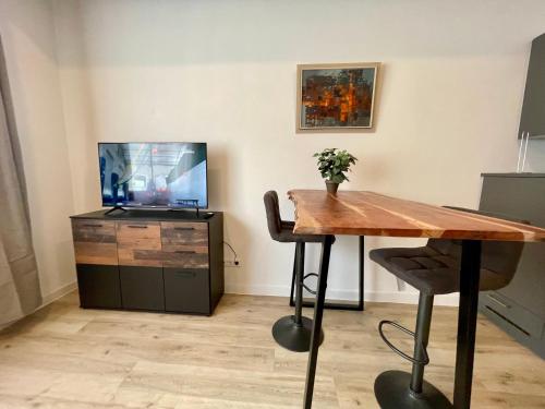 a dining room with a wooden table and a tv at Wunderschönes Apartment am Schlössle Zentrum Pforzheim in Pforzheim