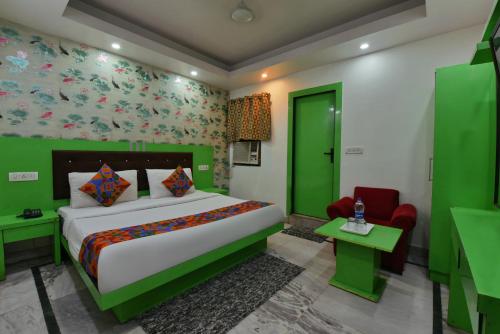 1 dormitorio con cama y pared verde en Hotel Noida International - opposite Mercedes Showroom Noida Sector 11 en Nueva Delhi