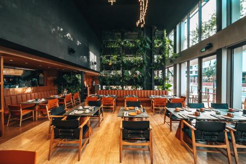 a restaurant with tables and chairs and windows at M Boutique Hotel - Designed for Adults in Paphos City