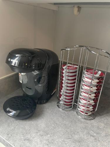 a pile of plates sitting next to a microwave at 3 Bedroom House Ashford, Kent - Free Parking - Free WiFi - Big Monthly Discounts - Sleeps 5 - Elite Stays UK in Ashford