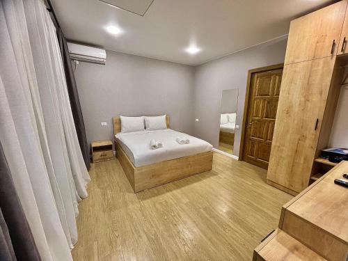 a bedroom with a bed and a wooden floor at Greenwood in Borjomi
