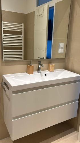 a bathroom with a white sink and a mirror at Apartments Villa Prima in Privlaka