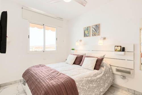 a bedroom with white walls and a bed with pillows at Sandra Amadores in Puerto Rico de Gran Canaria