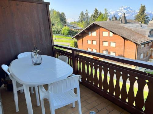 a white table and chairs on a balcony at Beryl Flat for 5, stunning views in Villars-sur-Ollon