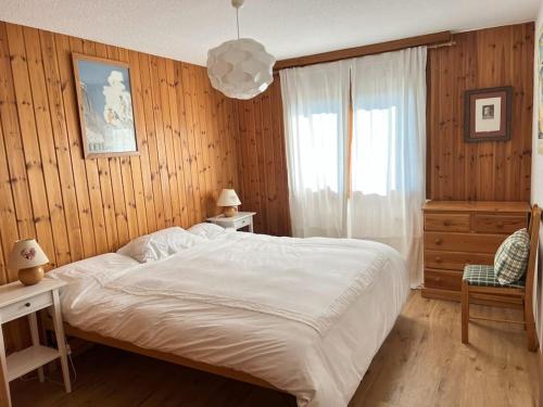 a bedroom with a large white bed and a window at Beryl Flat for 5, stunning views in Villars-sur-Ollon
