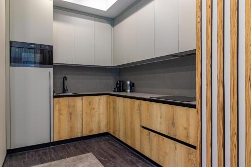 a kitchen with white cabinets and a wooden counter top at Shelter Apart Hotel in Bukovel
