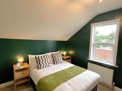 um quarto verde com uma cama e uma janela em Melbury Rooms & Studios em Exeter