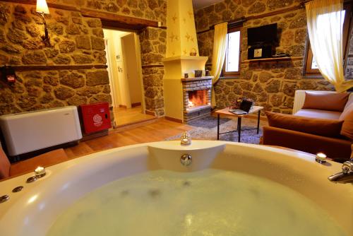 a large bath tub in a room with a fireplace at Mavraganeiko in Synikia Mesi Trikalon
