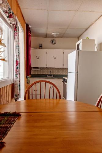 a kitchen with a wooden table and a white refrigerator at Waterside Apts. in Cardigan