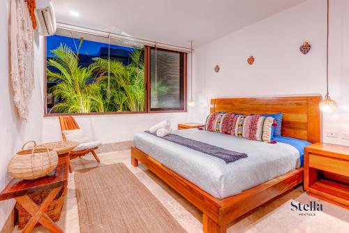 a bedroom with a bed and a desk and a window at Private Rooftop 1BR Condo with Stunning Common Areas in Tulum