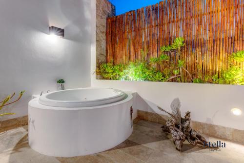 a bathroom with a toilet and a painting on the wall at Private Rooftop 1BR Condo with Stunning Common Areas in Tulum