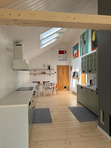 a kitchen with white counters and a wooden floor at Dom w Starym Sadzie z basenem i sauną - Beskid Wyspowy in Nowe Rybie