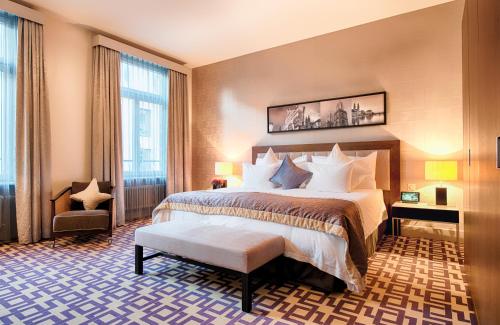 una camera d'albergo con un letto e una grande finestra di Alden Suite Hotel Splügenschloss Zurich a Zurigo