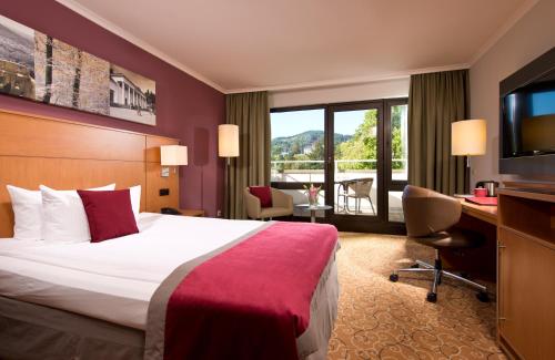 Habitación de hotel con cama y TV en Leonardo Royal Hotel Baden- Baden en Baden-Baden