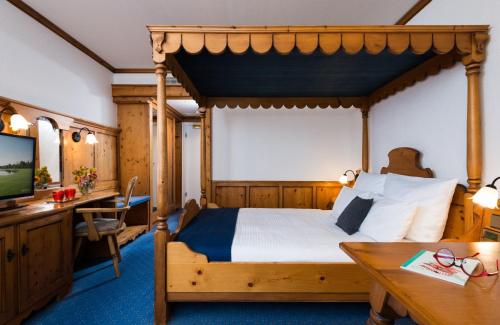 um quarto com uma cama, uma secretária e uma televisão em Leonardo Hotel Munich Arabellapark em Munique