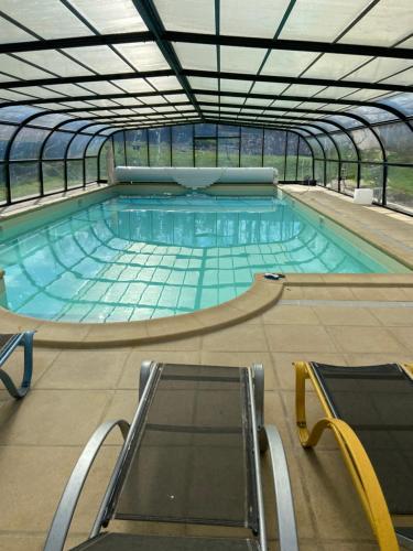 a large swimming pool in a glass building at Les Oiseaux Résidence 