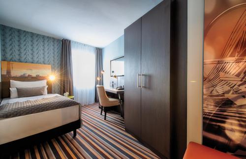 a hotel room with a bed and a desk at Leonardo Boutique Hotel Düsseldorf in Düsseldorf