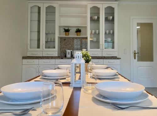 a kitchen with a table with white plates and bowls at Casa en 1ª línea del mar - House on Sea Front Valdoviño in Valdoviño