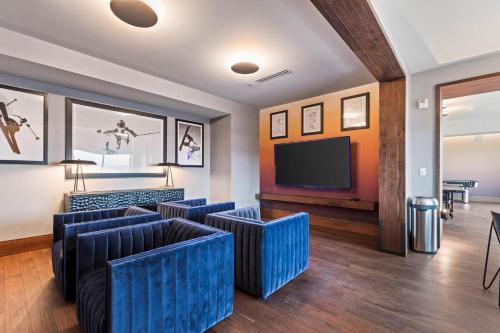 a lobby with blue chairs and a flat screen tv at Black Rock Ridge 14202 by Moose Management in Park City