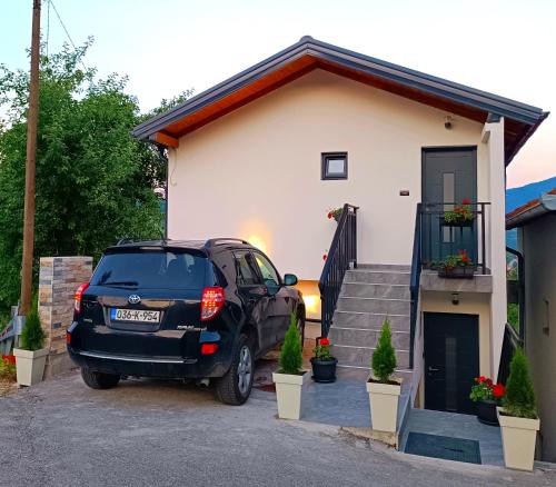 a black truck parked in front of a house at Apartmani Višegradski pogled in Višegrad