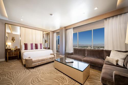 um quarto de hotel com uma cama e um sofá em SAHARA Las Vegas em Las Vegas