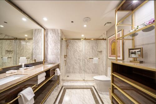 a bathroom with a shower and a sink and a toilet at SAHARA Las Vegas in Las Vegas