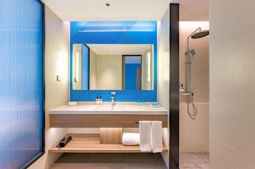a bathroom with a sink and a mirror at Holiday Inn Express Langfang Yanjiao by IHG in Langfang