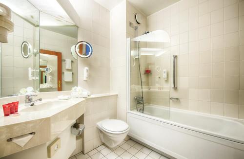 a bathroom with a toilet and a sink and a shower at Leonardo Hotel Aachen in Aachen