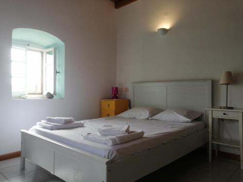 een slaapkamer met een wit bed en handdoeken bij Evgenia's Traditional House in Logothetiánika