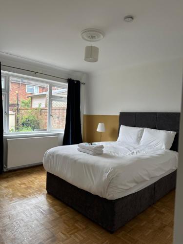 een slaapkamer met een groot bed en een raam bij Dartford Stay in Kent