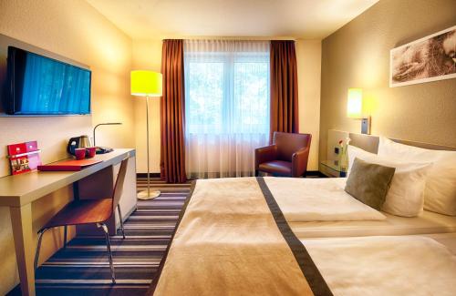 Ένα ή περισσότερα κρεβάτια σε δωμάτιο στο Leonardo Hotel Mannheim-Ladenburg