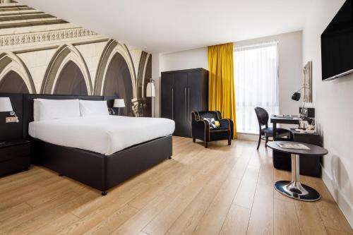 ニューカッスル・アポン・タインにあるホテル インディゴ ニューキャッスルのベッドとデスクが備わるホテルルームです。