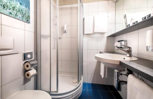 La salle de bains est pourvue d'une douche, de toilettes et d'un lavabo. dans l'établissement Leonardo Boutique Hotel Rigihof Zurich, à Zurich
