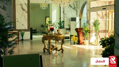 una habitación con una mesa con gafas. en Al Andalus Tolen Hotel en Yeda