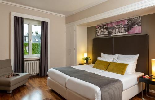 a hotel room with a large bed and a window at Leonardo Royal Hotel Mannheim in Mannheim