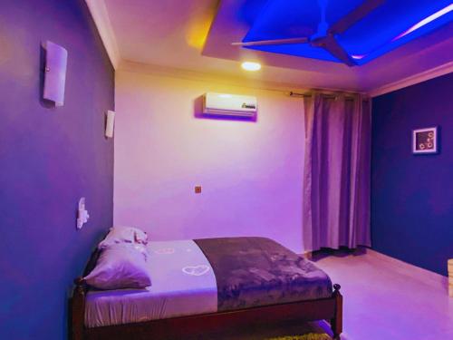 a room with a bed with purple lights on it at Evame Studio Apartment 