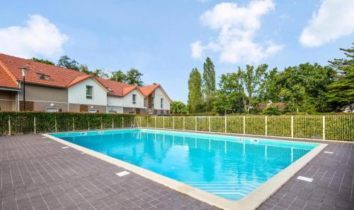 - une piscine dans une cour à côté d'une clôture dans l'établissement Le Domaine du Bois de la Grée - maeva Home - Maison 3 pièces 6 personnes - Sélection MAE-7904, à Pornichet