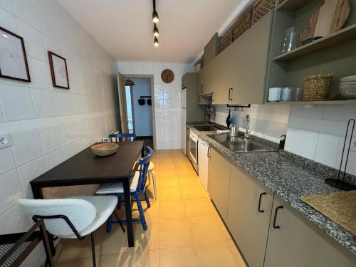 a kitchen with a counter and a table and chairs at O Faiado Da Ria By Oktheway in Culleredo