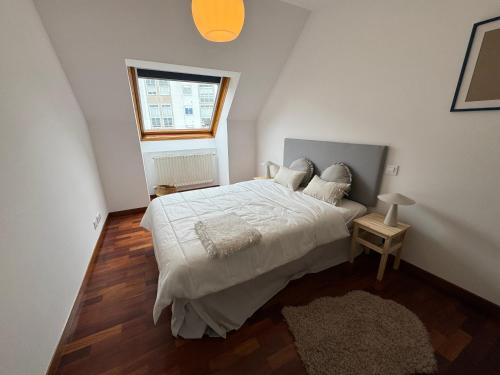 a bedroom with a large white bed with a window at O Faiado Da Ria By Oktheway in Culleredo