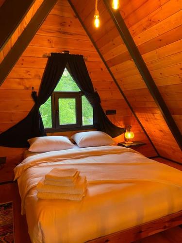 a bedroom with a bed in a wooden cabin at Nesli Villa & Bungalow - 1 no'lu Bungalov (1+1) in Rize