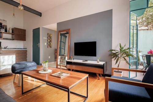 a living room with a tv and a table at Bright & Stylish Apt With Balcony Reforma Avenue in Mexico City
