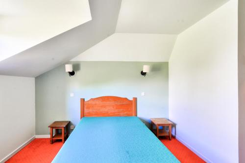 - une chambre avec un lit bleu et deux bancs dans l'établissement La résidence du Lac - maeva Home - Appartement 2 pièces 5 personnes - Sélection MAE-4461, à Monflanquin