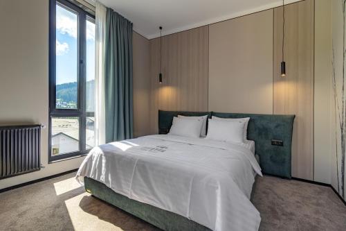 a bedroom with a large bed and a large window at Shelter Apart Hotel in Bukovel