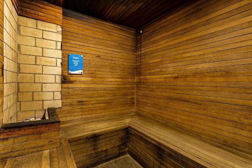um canto de uma sauna de madeira com um sinal azul em Studio à beira mar - Hotel Jurerê Beach Village em Florianópolis