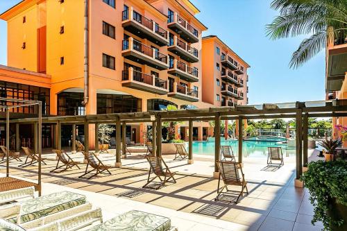 a hotel patio with chairs and a swimming pool at Studio à beira mar - Hotel Jurerê Beach Village in Florianópolis