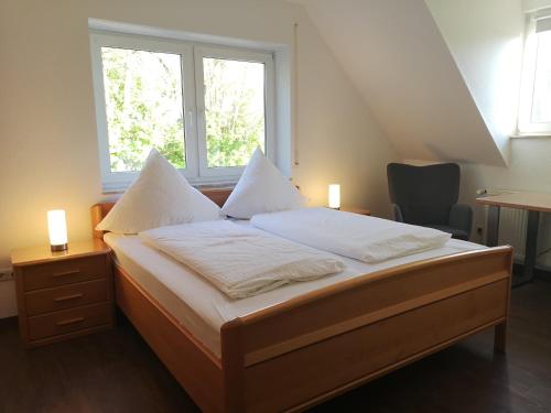 a bedroom with a bed with white sheets and a window at Ferienzimmer Schneider in Herbstein