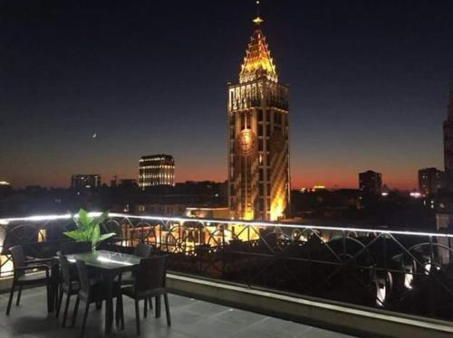 a building with a clock tower at night at Schöne Wohnung mitten im Zentrum von Batumi in Batumi